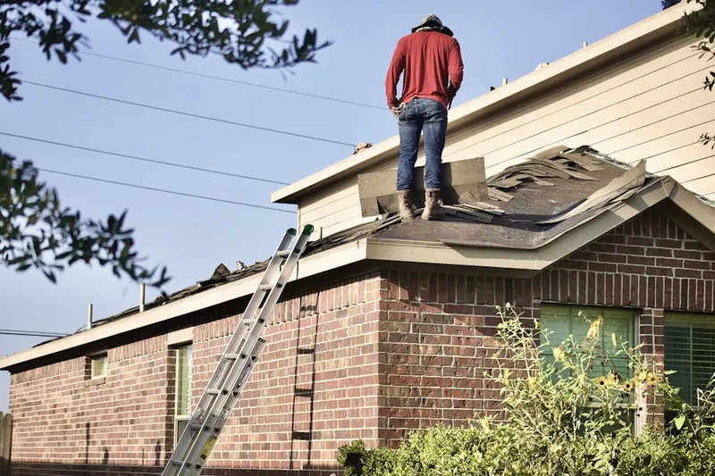 Professional roofer working on a residential roof in Sharon